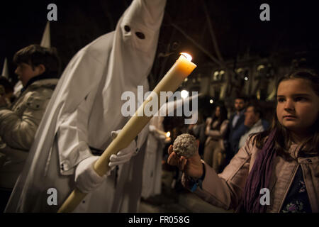 Séville, Espagne. Mar 20, 2016. Un pénitent de fraternité appelé ''La Paz'' cire actions avec une fille lors de son défilé de la cathédrale le Dimanche des Rameaux, jour appelé Domingo de Ramos en espagnol. © Daniel Gonzalez Acuna/ZUMA/Alamy Fil Live News Banque D'Images