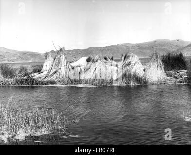 Apr 18, 1956 - Le lac Titicaca, l'Amérique du Sud - Lac Titicaca est entre la Bolivie et le Pérou, 12 300 pieds de haut dans les Andes en Amérique du Sud. C'est plus de 100 miles de long et 60 de large et si presque comme une mer intérieure, l'eau est douce et provient de nombreuses petites rivières qui se jettent dans la montagne environnante. Qu'une rivière coule à l'extérieur du lac et il disparaît dans les déserts semi inconnu de haut de la Bolivie. Les gens qui vivent autour du lac sont principalement des Indiens aymaras, les survivants d'une une ancienne civilisation qui vivait dans la région bien avant que les Conquistadors Espagnols sont arrivés, et qui neve Banque D'Images