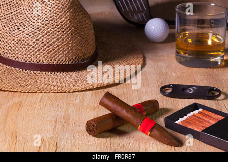 Siesta - cigare, chapeau de paille,whisky écossais et le golf conducteur sur une table en bois Banque D'Images