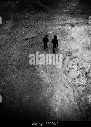 Deux adolescents à pied le long d'un chemin couvert de neige en hiver comme vu à partir d'une position de l'antenne et d'un point de vue photographique à la bas Banque D'Images