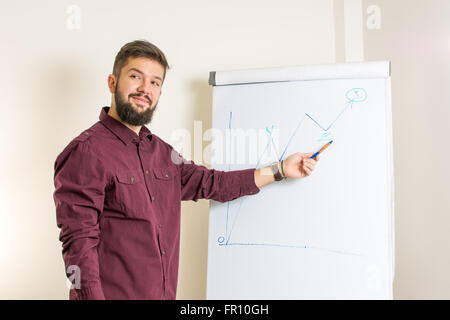 Jeune homme barbu présentant par le tableau Banque D'Images