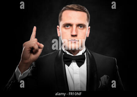 Jeune homme montre doigt vers le haut. Banque D'Images