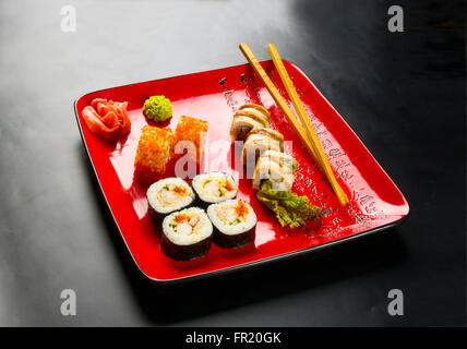 Still Life - régler les rouleaux sur une plaque rouge sur fond noir Banque D'Images