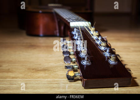 La tête brune cou de guitare 12 lyinh sur plancher en bois libre Banque D'Images