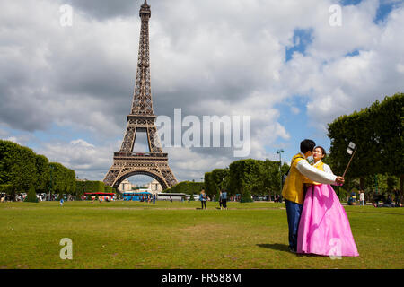 Couple avec asiatique traditionnel posant pour selfy en face de Tour Eiffel à Paris, France Banque D'Images