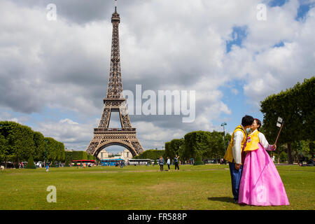 Couple avec asiatique traditionnel posant pour selfy en face de Tour Eiffel à Paris, France Banque D'Images