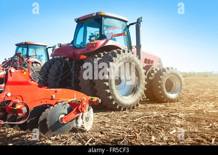 Deux tracteurs dans un champ sur une journée ensoleillée Banque D'Images