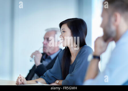 Smiling businesswoman listening in meeting Banque D'Images