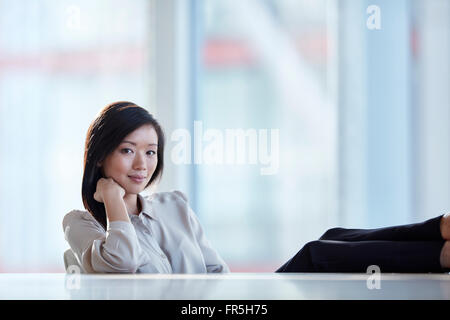 Confident businesswoman Portrait avec pieds Banque D'Images