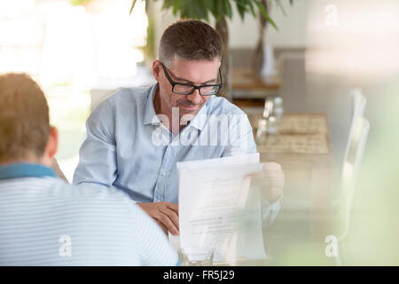 Businessman Consultation des notes in cafe Banque D'Images