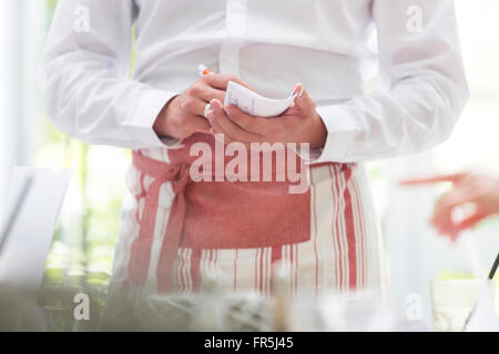 Waiter taking order in restaurant Banque D'Images