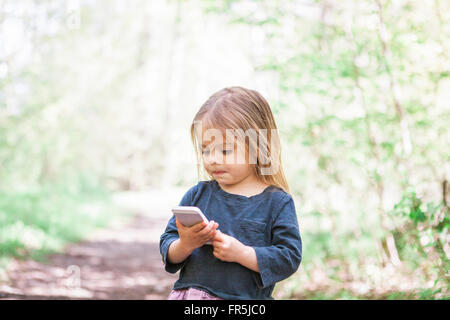 Woman using cell phone in park Banque D'Images