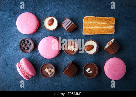 Composition de chocolats et de macarons roses, horizontal super still life Banque D'Images