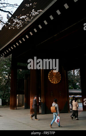 Les gens marcher sous la première floraison des cerisiers au sanctuaire de Yasukuni à Tokyo, Japon, le 21 mars 2016. L'Agence météorologique japonaise a annoncé officiellement la saison des cerisiers en fleur à Tokyo ont commencé 5 jours plus tôt que la moyenne et deux jours plus tôt que l'an dernier. L'Agence s'attend à ce que la sakura pour être en pleine floraison dans environ une semaine. © Rodrigo Reyes Marin/AFLO/Alamy Live News Banque D'Images