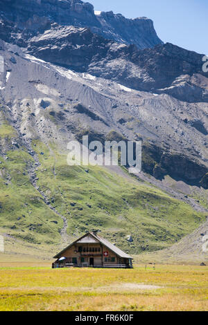 Chalet en bois dans les montagnes suisses entouré de prairie Banque D'Images