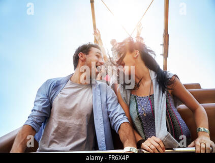 Jeune couple enivré sur amusement park ride Banque D'Images