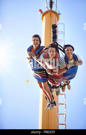 Portrait of smiling friends saut à amusement park Banque D'Images