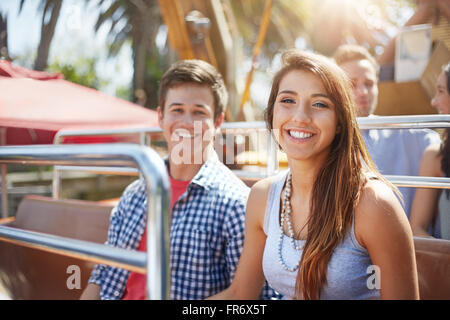 Portrait of smiling young couple on amusement park ride Banque D'Images