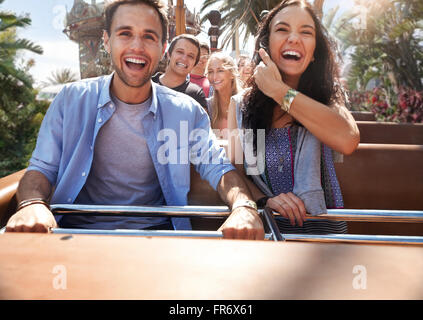 Les jeunes enthousiastes couple riding amusement park ride Banque D'Images