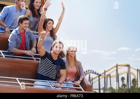 Portrait young man giving thumbs-up sur amusement park ride Banque D'Images