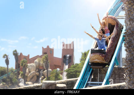 Amis enthousiaste acclamant log amusement park ride Banque D'Images