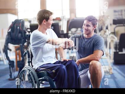 Thérapeute physique fist bumping man in wheelchair Banque D'Images