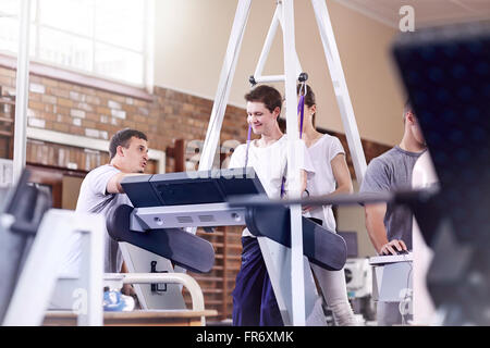 Les thérapeutes physiques homme directeurs sur tapis roulant Banque D'Images
