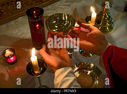 Le prêtre commence à lever le calice à l'autel au cours de la Sainte Communion dans une église catholique Anglo- Banque D'Images