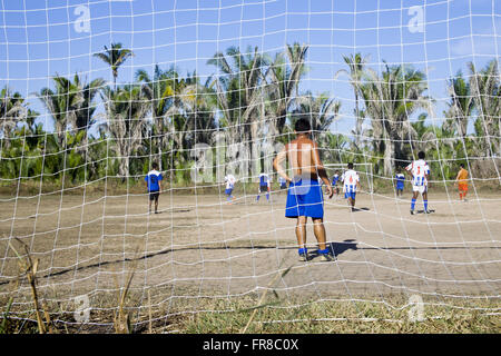 Gardien de regarder le match de foot à la campagne avec des palmiers babassu dans l'arrière-plan Banque D'Images