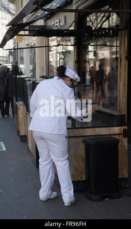 Cook femme nettoie écran de verre à Paris France en hiver Banque D'Images