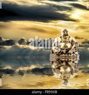 Arrière-plan de Feng Shui. Laughing Buddha ou Budai se reflète dans l'eau au lever du soleil Banque D'Images