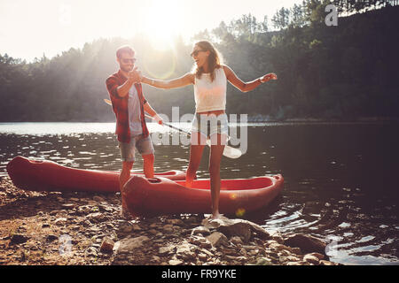 Jeune homme femme aidant à sortir d'un kayak. Après quelques kayak dans le lac sur une journée ensoleillée. Banque D'Images