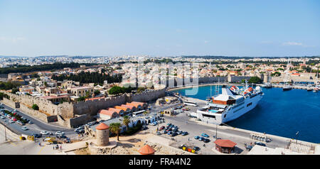 Une vue panoramique vue sur l'horizon du port de Rhodes, Grèce avec un petit bateau de croisière et vue sur le village historique fortifiée sur la mer Égée Banque D'Images