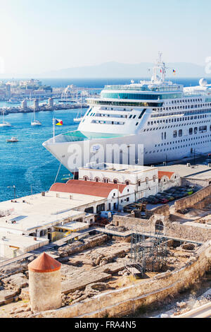 Une image couleur d'un petit bateau de croisière amarré dans le port de Rhodes, Grèce avec des parties de la ville ancienne en cours de restauration dans l'avant-plan Banque D'Images