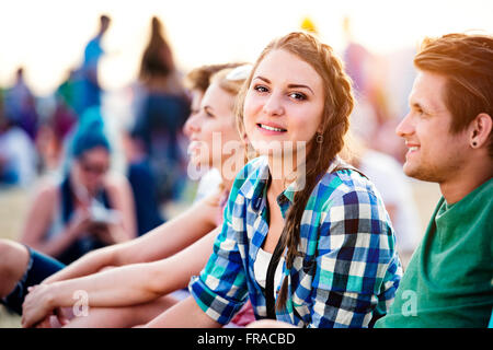 Les adolescents au festival de musique d'été, assis sur le sol Banque D'Images