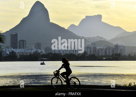 Circonscription de cyclistes sur la piste cyclable Lagoa Rodrigo de Freitas coucher du soleil Banque D'Images