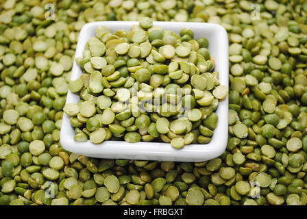 Diviser les pois verts dans un bol carré sur un fond de petits pois Banque D'Images