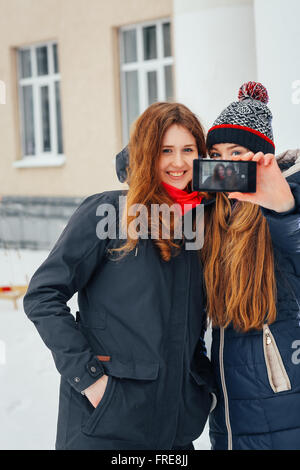 Deux belles filles faisant sur fond blanc selfies Banque D'Images