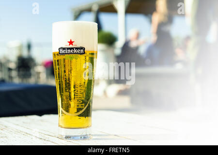 Verre de la bière Heineken sur une table en bois Banque D'Images