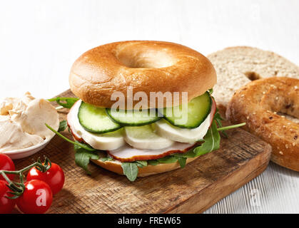 Sandwich bagel frais sur planche à découper en bois Banque D'Images