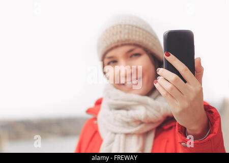 Jeune femme à l'aide de mobile taking photo ou de l'envoi de message à l'extérieur Banque D'Images