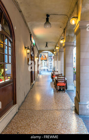 La vue quotidienne de passage de Bologne avec reataurant tables. Banque D'Images