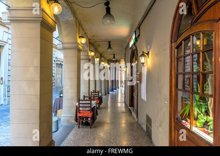 La vue quotidienne de passage de Bologne avec reataurant tables. Banque D'Images