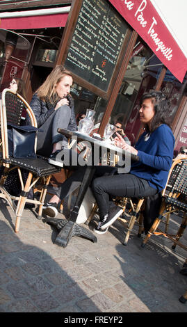 Les jeunes femmes à la terrasse d'un café à Paris France en hiver Banque D'Images