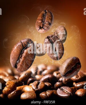 Grains de café torréfiés sur fond orange Banque D'Images