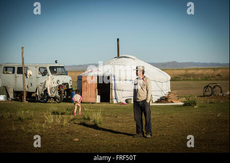 Un homme en face de son ger (yourte) en Mongolie. Banque D'Images