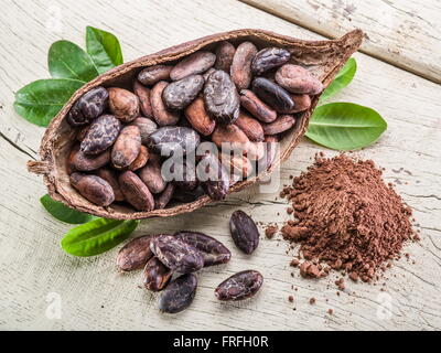 La poudre de cacao et les grains de cacao sur la table en bois. Banque D'Images