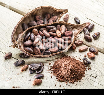 La poudre de cacao et les grains de cacao sur la table en bois. Banque D'Images