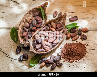 La poudre de cacao et les grains de cacao sur la table en bois. Banque D'Images