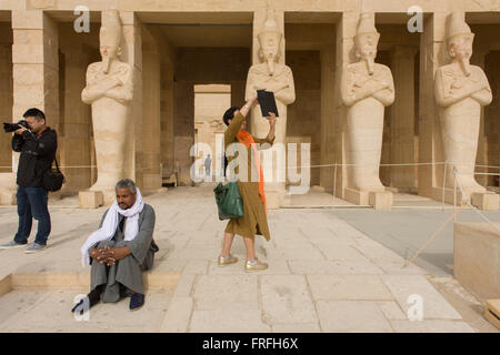 Un groupe de touristes de langue chinoise de profiter de l'expérience de visiter l'Ancien Temple égyptien d'Hatshepsout près de la Vallée des Rois, Louxor, vallée du Nil, en Égypte. Le temple funéraire de la reine Hatshepsout, le Djeser-Djeseru, est située sous les falaises de Deir el Bahari ('le Monastère du Nord'). Le temple funéraire est dédié au dieu soleil Amon-Ra et est considéré comme l'un des "monuments incomparables de l'Égypte ancienne." Le temple a été le site du massacre de 62 personnes, surtout des touristes, par les Islamistes le 17 novembre 1997. Banque D'Images